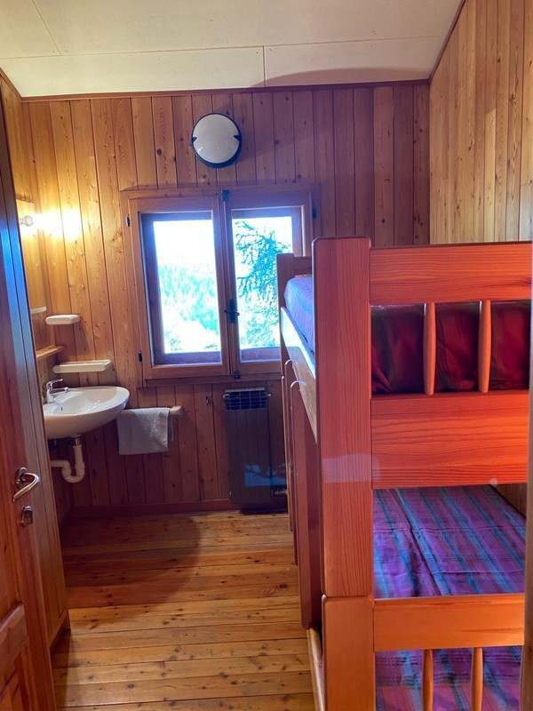 Chambre avec lits superposés et lavabo.