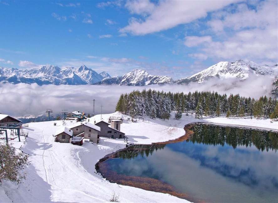 Le lac Lod gelé, entouré de chalets, sous la neige.